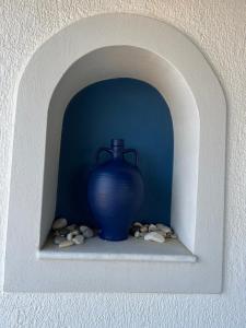 纳克索乔拉pirgaki seaside house的蓝色的花瓶,坐在墙上的架子上