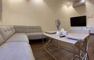 麦加2 Bedrooms Apartment in Makkah的客厅配有沙发和带电视的桌子