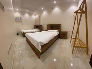 麦加2 Bedrooms Apartment in Makkah的一间设有两张床的客房,墙上挂着一幅画