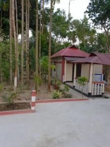 巴纳内拉斯Sunapur Mini Resort Sylhet的前面有一根红白的柱子的小房子