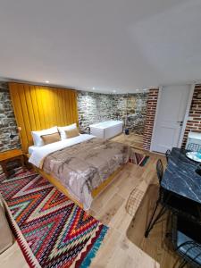 吉诺卡斯特"Villa 70" Guesthouse的一间卧室设有一张大床和砖墙