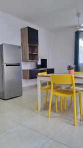 博卡奇卡Villa Roberta的厨房配有黄色桌子和冰箱