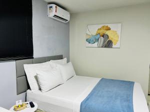 圣路易斯Edifício Creta的卧室配有白色的床和绘画作品