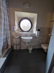 蒙扎奥斯特罗科斯塔阿尔塔酒店的一间带水槽和卫生间的浴室以及窗户。
