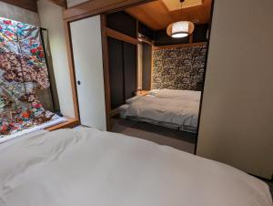 尾道市SIDOU 　INN的卧室配有白色的床和窗户。