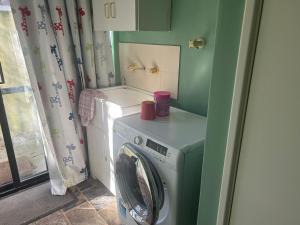 珀斯Single room share bathroom and kitchen的洗衣房配有洗衣机和洗衣机