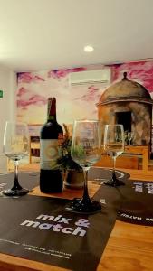 卡塔赫纳Edif HA的一张桌子,上面放有三杯酒和一瓶葡萄酒