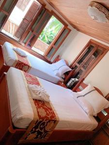 琅勃拉邦遗忘时光Guesthouse Sky dragon Guesthouse的一间卧室设有两张床和窗户。
