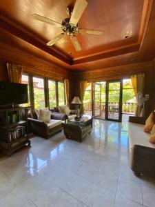 湄南海滩班拉加河内别墅酒店的带沙发和吊扇的客厅