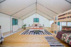 CassvilleRoaring River Luxury Glamping #4的一间设有床铺和双层床的房间