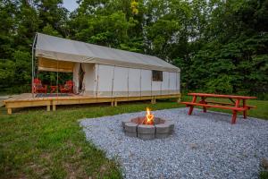 CassvilleRoaring River Luxury Glamping #4的帐篷,配有火坑和野餐桌