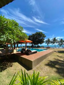 湄南海滩班拉加河内别墅酒店的一个带游泳池和遮阳伞的度假胜地