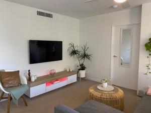 穆卢拉巴Nova Apartment Mooloolaba Beach的客厅设有壁挂式平面电视。