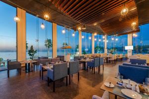 阿可贺巴HDB Al Khobar Resort & Spa的餐厅设有桌椅和大窗户。