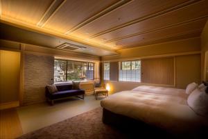 GiommachiHotel Yuraku Kyo-yasaka的酒店客房带一张床、椅子和窗户