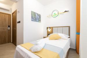 奥布罗瓦茨Hotel Kanjon Zrmanje的一间卧室配有带白色床单和黄色枕头的床。