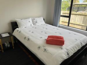 奥克兰Yucca Home的一间卧室配有一张红色枕头的床