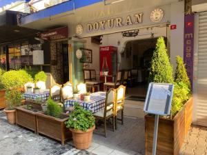 伊斯坦布尔戈吉斯公寓式酒店的餐厅前面设有桌椅