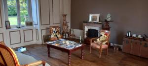 圣莱奥纳尔德诺布拉Chambres d'hôtes La Babinerie的客厅配有桌椅和壁炉