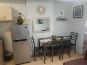 宿务Mivesa Garden Residences的一间带桌子和冰箱的用餐室