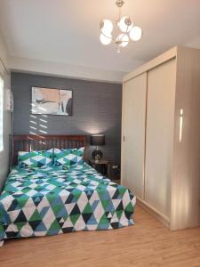 宿务Mivesa Garden Residences的一间卧室配有一张带绿色和白色棉被的床