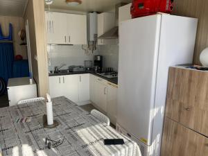 德哈恩Camping Esmeralda的厨房配有白色橱柜和白色冰箱。