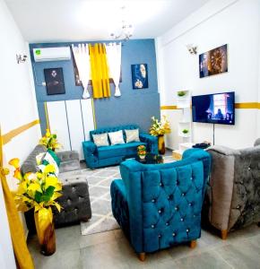 杜阿拉Appartement meublé的客厅配有蓝色椅子和沙发