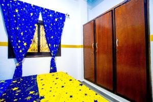 杜阿拉Appartement meublé的一间卧室配有一张带蓝色窗帘的星星床