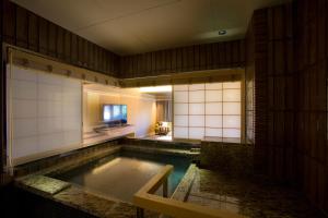 GiommachiHotel Yuraku Kyo-yasaka的一个带浴室的房间里,有一个大池水