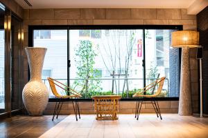 福冈Tomariehotel & condominium的大堂设有桌椅和大窗户。
