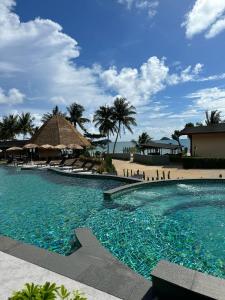 象岛Kai Bae Beach Resort Koh Chang的棕榈树海滩旁的大型游泳池