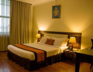 加德满都Vannasut Hotel and Spa的酒店客房设有一张大床和两盏灯。