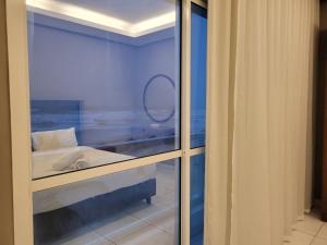 塞拉莱Salalah Beach Villas的客房设有带床和镜子的窗户。
