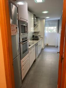 赫雷斯-德拉弗龙特拉XRYHOMES I Residencial en Jerez 4 hab, 2 baños, 7pax, 10 min del centro的厨房配有不锈钢用具,铺有瓷砖地板。
