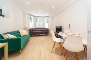 伦敦Kensington luxury flat with patio的客厅配有绿色沙发和桌子