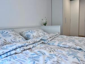 维也纳Danube22 Apartment的一张带蓝色和白色床单及枕头的床
