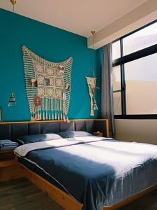 台南三田包棟旅宿MITA Inn的一间卧室设有一张蓝色墙壁的大床