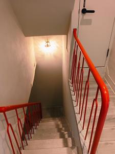 台南三田包棟旅宿MITA Inn的楼梯,墙上有红色栏杆和灯