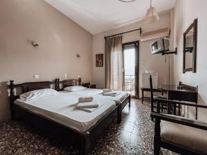斯科派洛斯Hotel Eleni的一间卧室设有两张床、一张桌子和一个窗口。