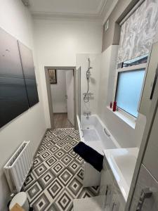哈罗盖特2 Bed ground floor apartment, sleeps 4 with free parking的浴室配有白色浴缸和水槽