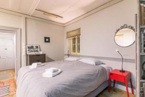 科孚镇Pentofanoro Central Studio - Corfu Cozy Getaway的一间卧室配有一张床和一张红色的桌子