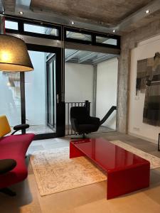 埃因霍温De Eindhovenaar City Apartments的客厅配有红色咖啡桌和椅子
