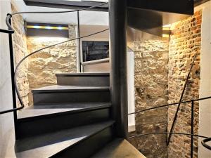 弗莱堡Historical Luxury Homes - Luxus Familien Suite的石墙房间内的螺旋楼梯