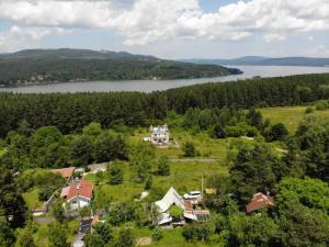 Shtarkelovo GnezdoКъща за гости Замък Никола的享有湖畔山丘上房屋的空中景致