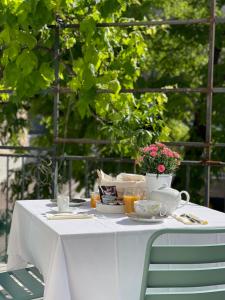 马赛Maison Dormoy的一张带碗碟和鲜花的白色桌子