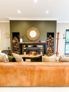 金德拜恩Hamilton House - Snowy Mountain Luxury Villas的带壁炉的客厅内的棕色沙发