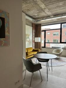 埃因霍温De Eindhovenaar City Apartments的客厅配有桌椅和沙发