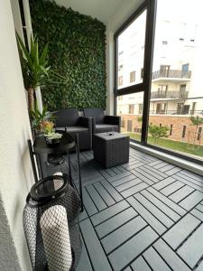 普瓦西Appartement avec son jardin d’hiver的一个带绿色墙壁和桌椅的庭院