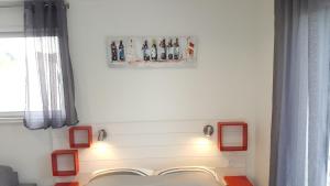 佩萨克Appartement Alouette France的墙上红色框架的房间里一张床位