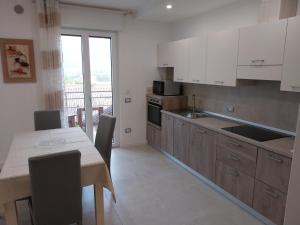 莱维科特尔梅Ca Giardina CIPAT 022104-AT-012586的厨房配有白色橱柜和桌椅